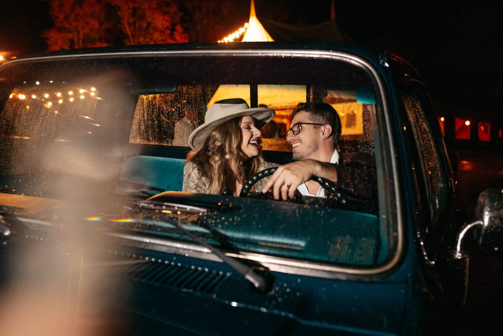 Bride & Groom cuddle up inside the front of the retro chevy truck.