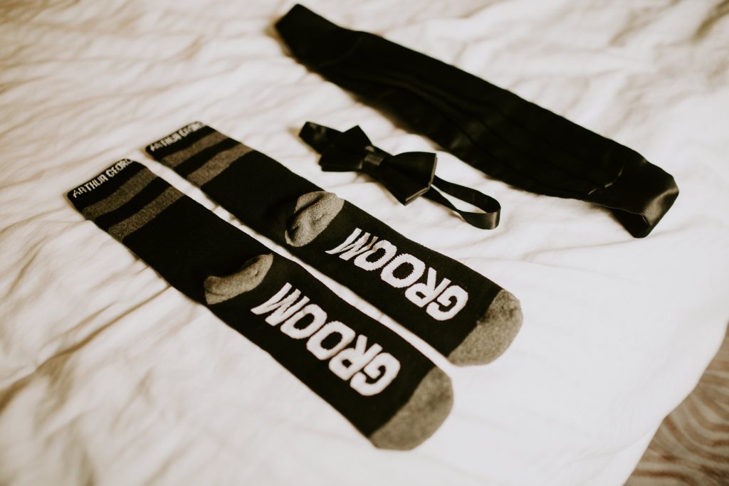 The grooms details do not disappoint with "Groom" written on the bottom of his socks and chic black satin bow tie and cumberbun.