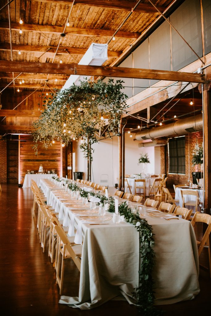 The head tablescape was a perfect mix of industrial chic. A greenery installation about softens the look and sets the space apart. 